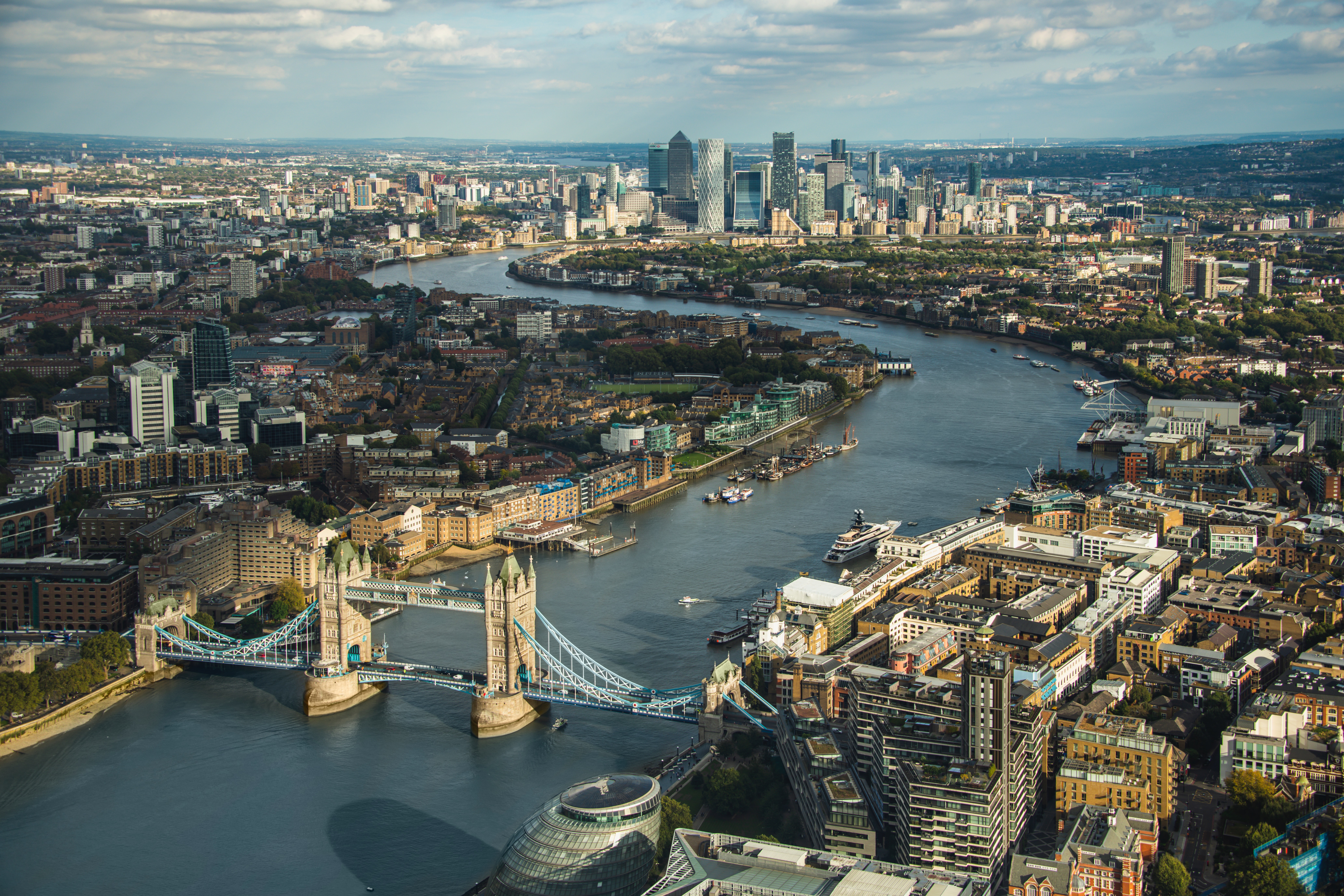 A picture of London on a clear day with blue skies and the Thames river winding through the city
